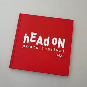 A red book with the words Pre order: 2023 Head On Photo Awards catalogue on it.