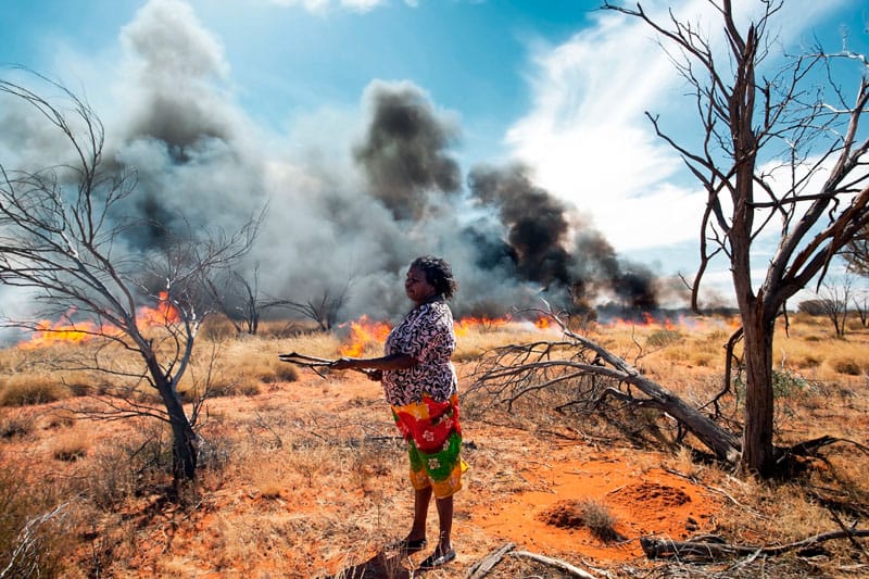 Indigenous woman firestick burning in outback Northern Territory.